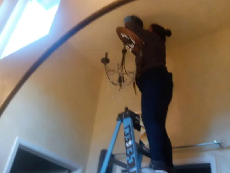 Electrician installing a chandelier in a Lombard residence